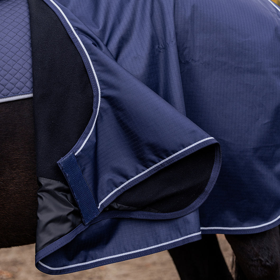 Detail der EQUEST Ausreitdecke Kingston Active in Navy, umgeschlagen mit sichtbarem schwarzem Fleecefutter